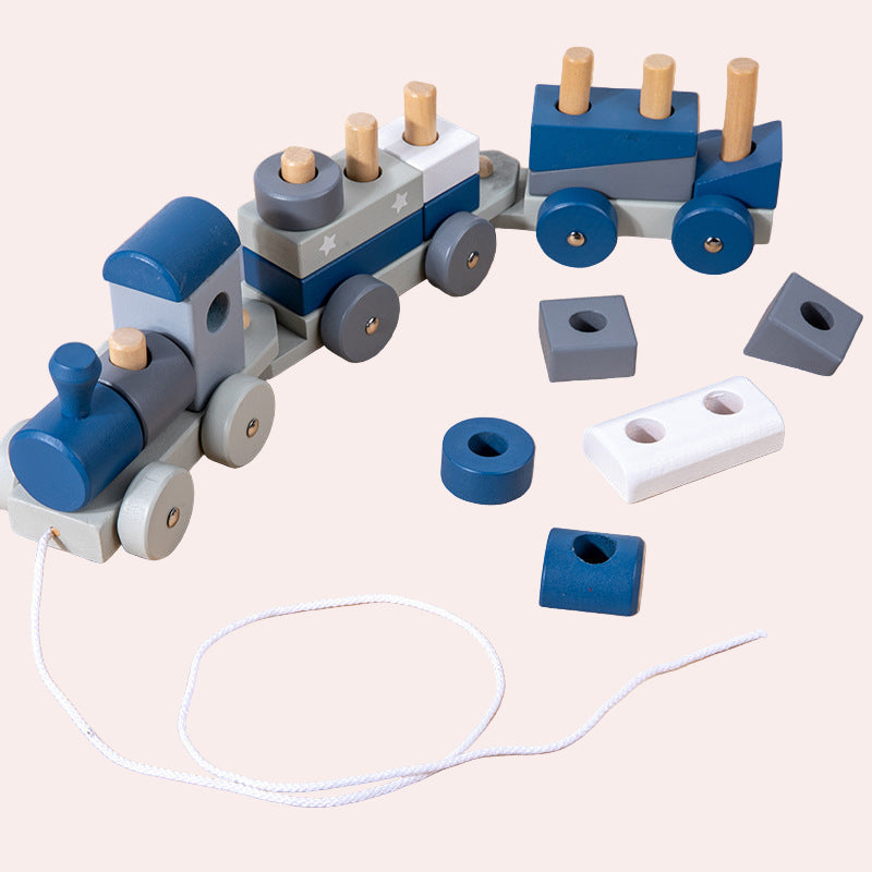 Wooden toy train set with blocks on a wooden surface